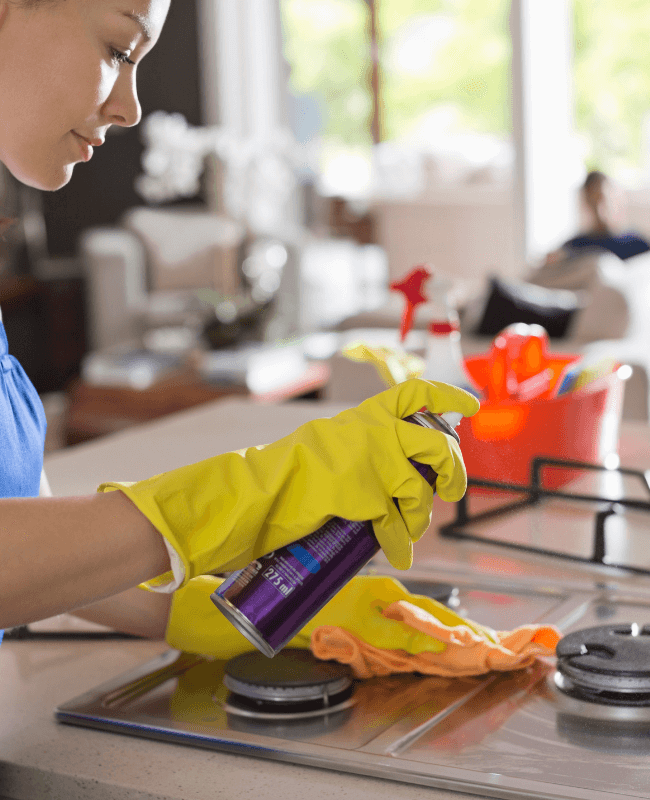 A professional cleaner scrubbing a stove in Austin, TX.